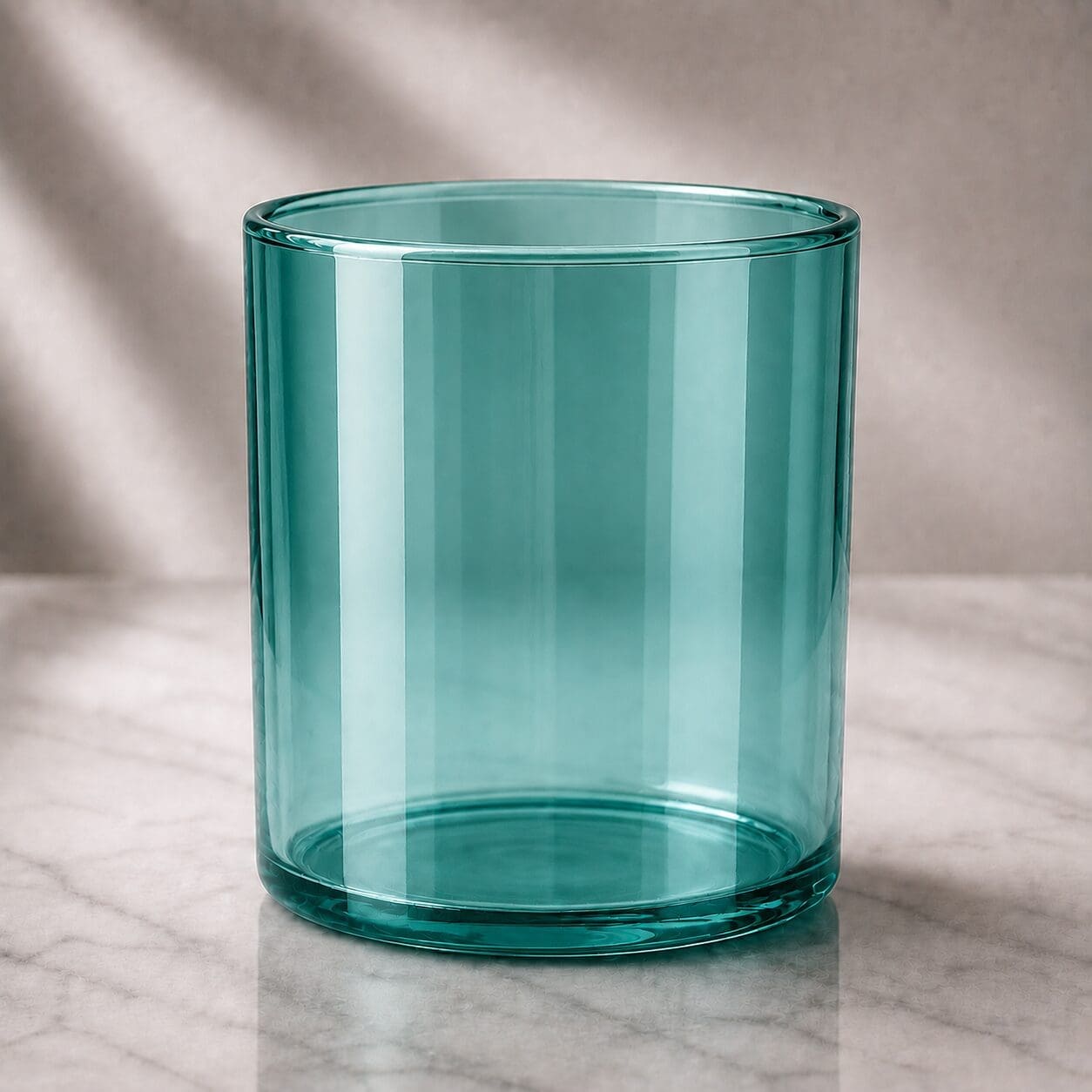 Turquoise glass cylinder jar with smooth finish, empty and ready for candle filling, decorating, or screen printing on marble surface with soft lighting