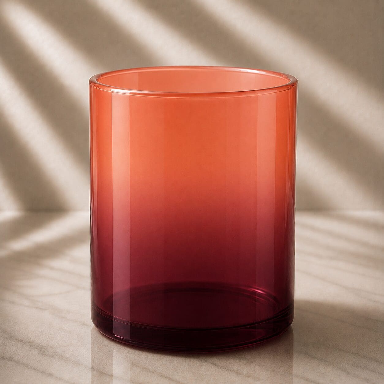 Red ombre glass cylinder vase with gradient coloring from coral top to deep burgundy bottom, displayed on marble surface with soft lighting