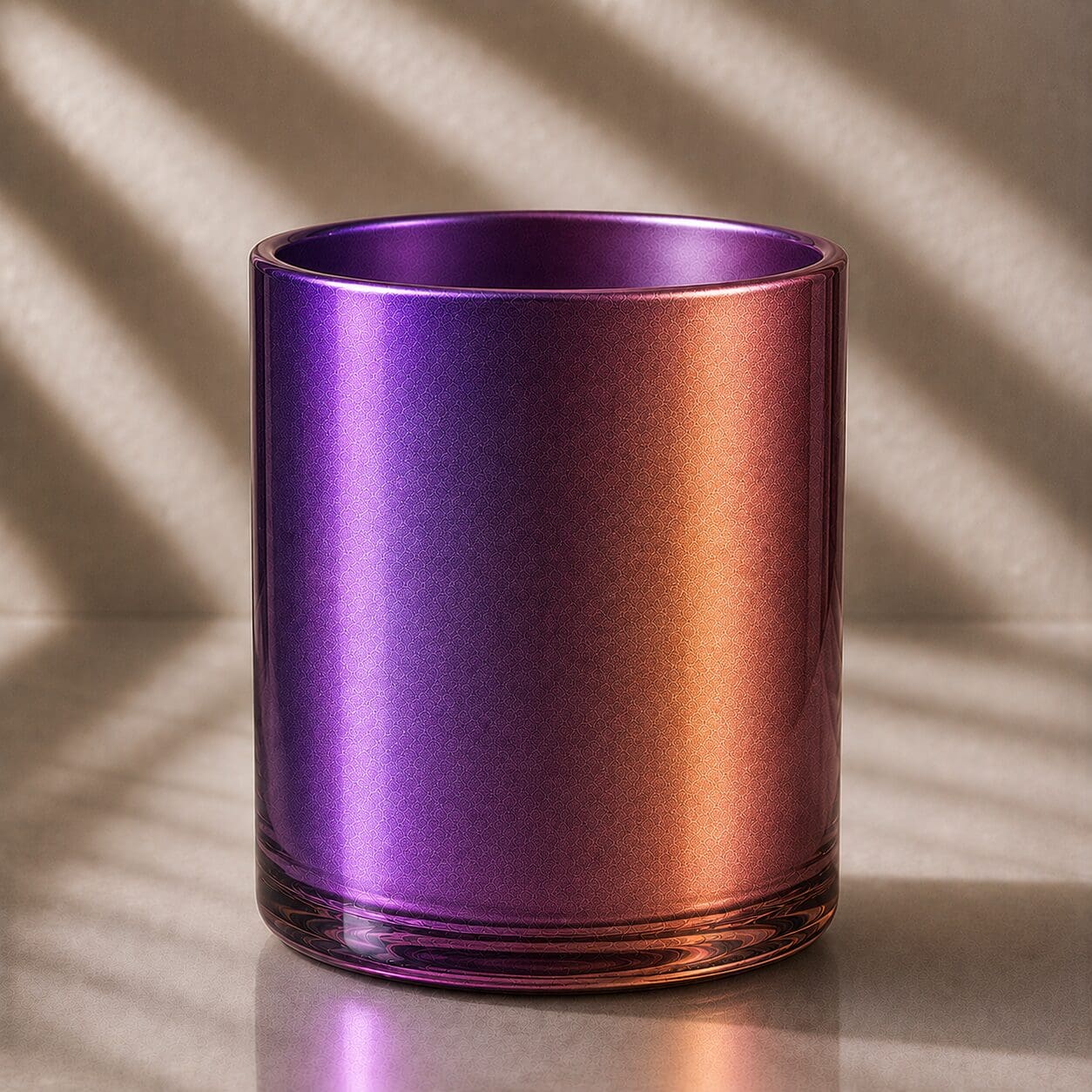 Iridescent purple and copper gradient glass cylinder with reflective metallic finish and diagonal sunlight casting shadows