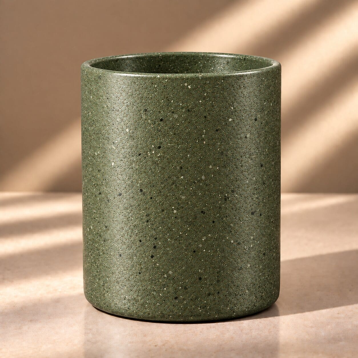 Sage green speckled cylindrical candle jar with spray coated finish and textured surface