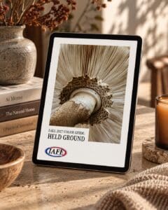 iPad displaying IAFF Fall 2027 Color Guide "Held Ground" featuring close-up of textured gourd on wooden desk with books, candle, and dried flowers